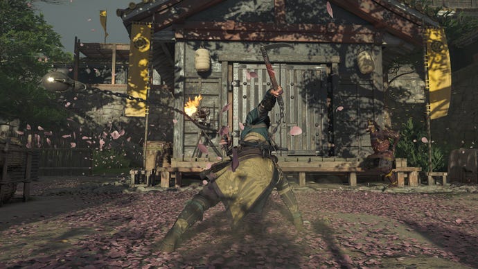 Naoe swings her kusarigama against an armored foe in Assassin's Creed Shadows, sending layers of sakura petals flying through the air.