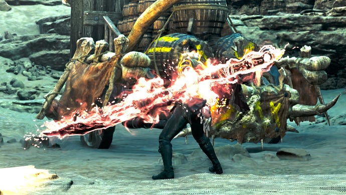 A hunter in Monster Hunter Wilds with their back to the camera charges up their Insect Glaive weapon until it's burning red and white with energy.
