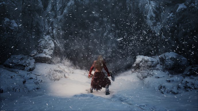 The player stands in the snow outside a cave.