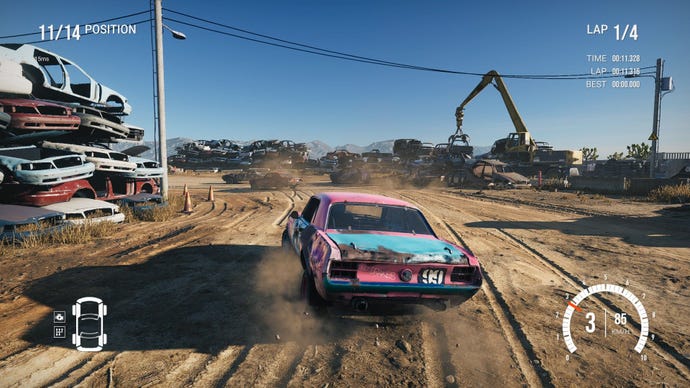 The player's pink and blue car drifts around a dusty corner in a scrapyard.